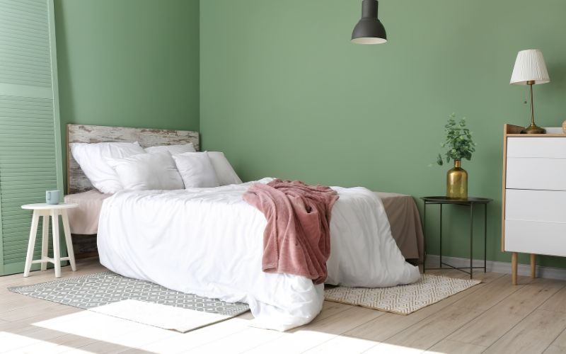Phòng ngủ màu xanh lá cây nhạt với nội thất trắng